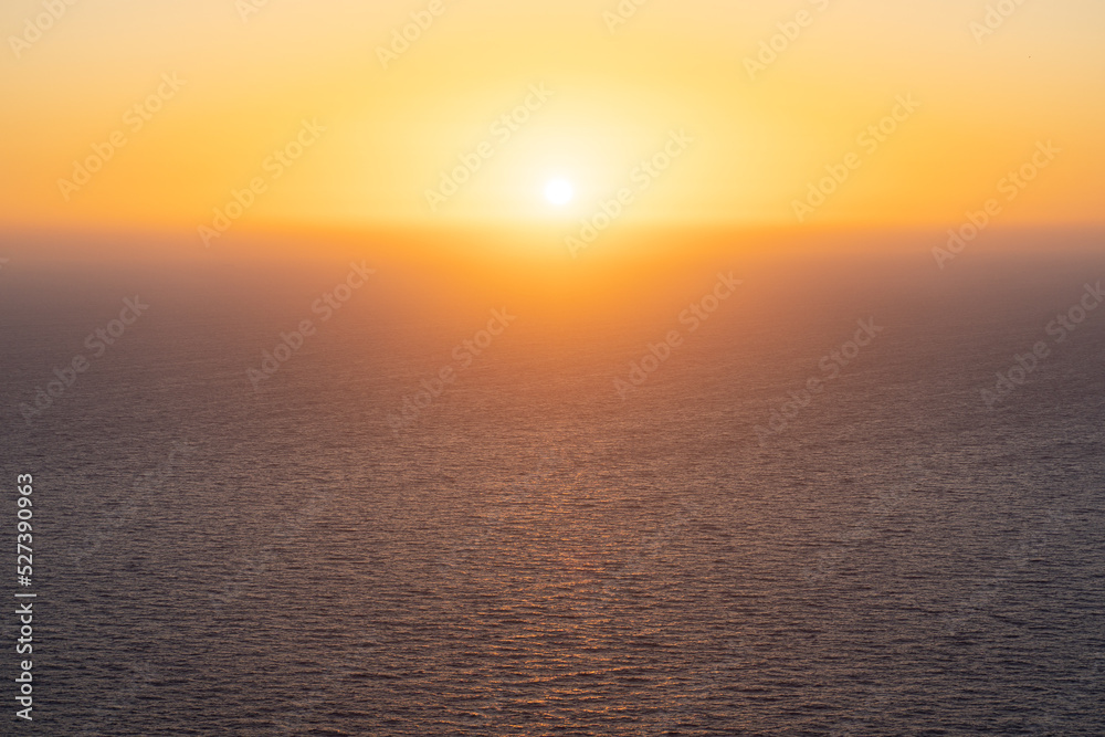Beautiful sunset over the sea. Orange sunset in the bright sky over the calm sea with sunlight reflection. Travel postcard concept, beautiful wallpaper, meditating picture