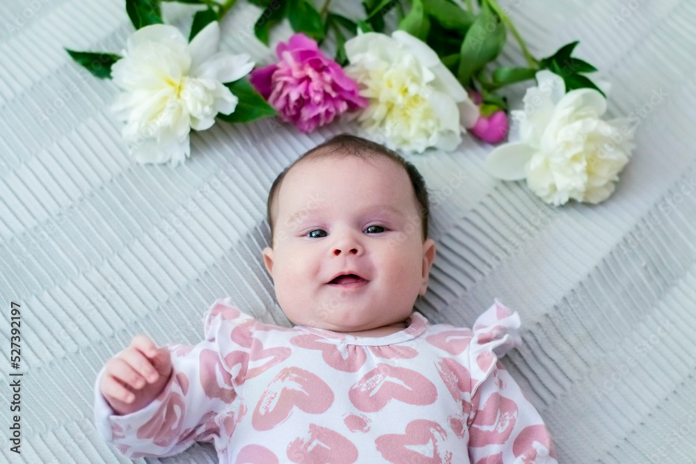 Little pretty girl with brown eyes with peony flowers. Happy laughing baby in flowers. Little pretty girl with brown eyes with peony flowers. Happy laughing baby in flowers.