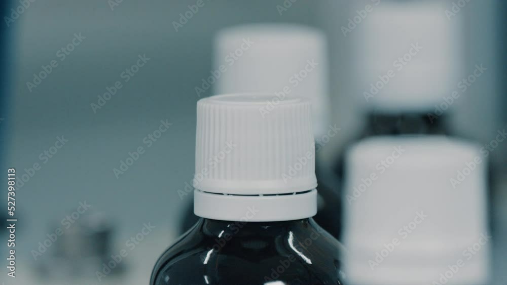 Automatic screwing of caps on a factory conveyor using industrial equipment. Production of pharmacological drugs in a modern factory. Medical or nutritional supplements production. Close up, DOF, 4K Automatic screwing of caps on a factory conveyor using industrial equipment. Production of pharmacological drugs in a modern factory. Medical or nutritional supplements production. Close up, DOF, 4K