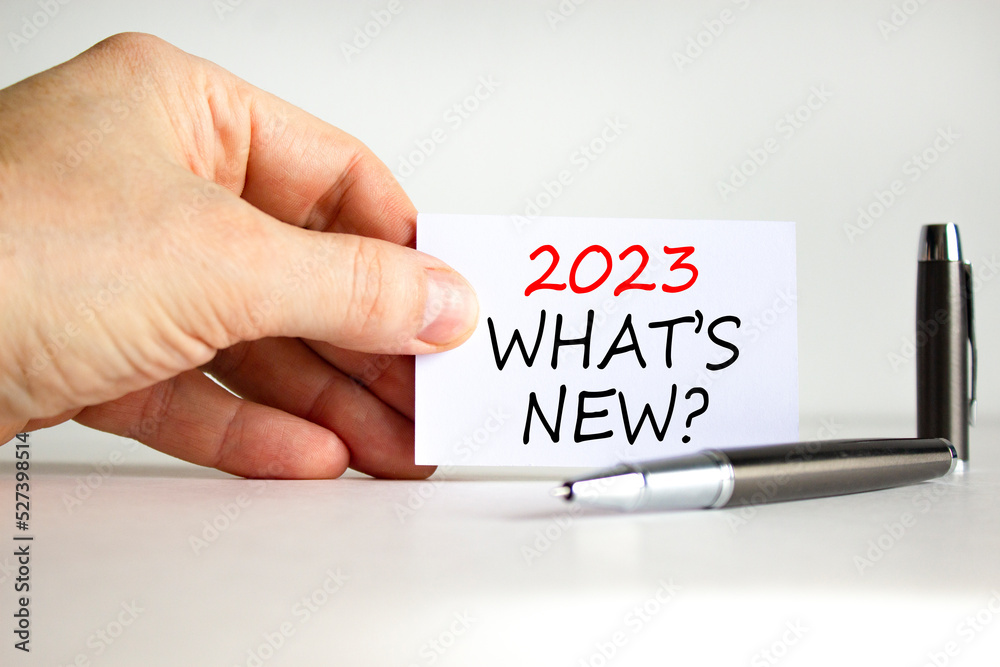 2023 what is new symbol. White card with words 2023 what is new. Businessman hand. Metallic pen. Beautiful white table white background. Business and 2023 what is new concept. Copy space. 2023 what is new symbol. White card with words 2023 what is new. Businessman hand. Metallic pen. Beautiful white table white background. Business and 2023 what is new concept. Copy space.