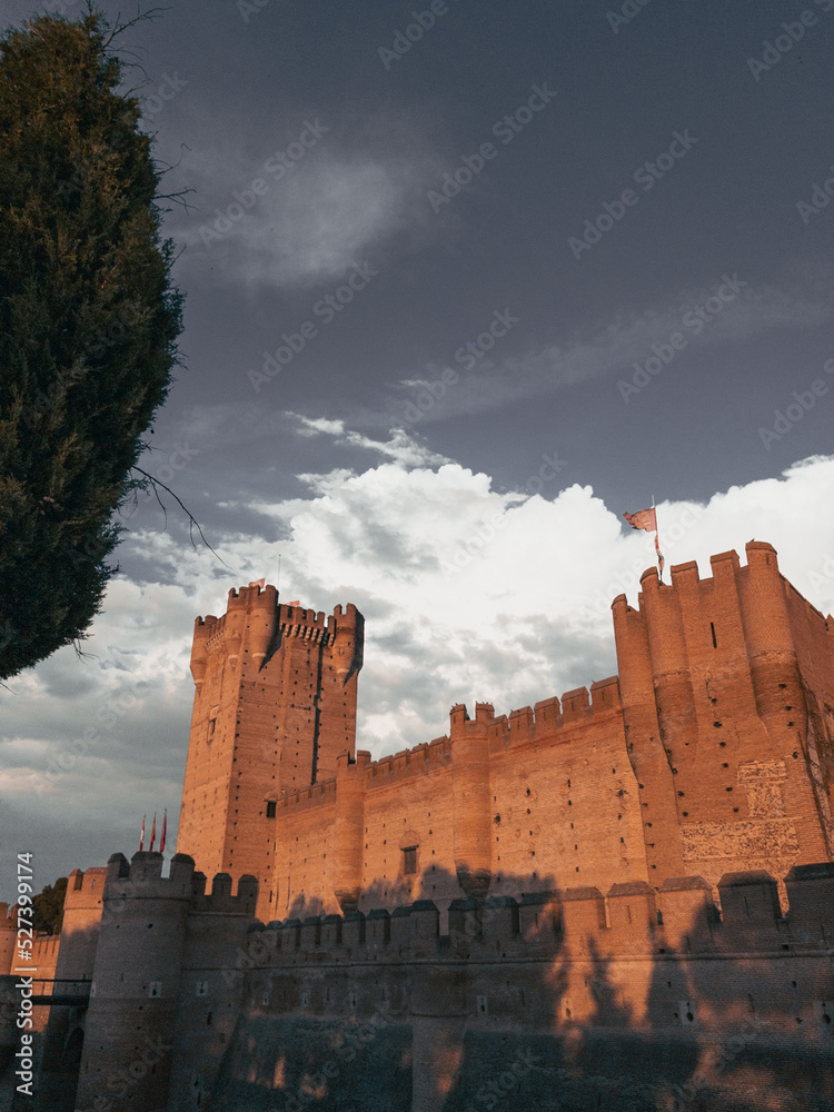 Ancient medieval castle with moat in front at sunset in Spain