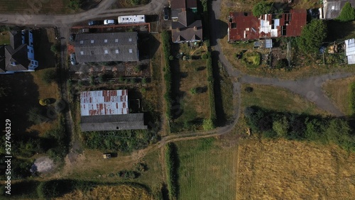 Top Down Aerial View of Green and Yellow Wheat Field Farm and Greenhouses. Golden Crops During Pasture Aerial View. Agricultural Work in Summer During Drought. Grain Crisis. Nature, Harvesting, Eco photo