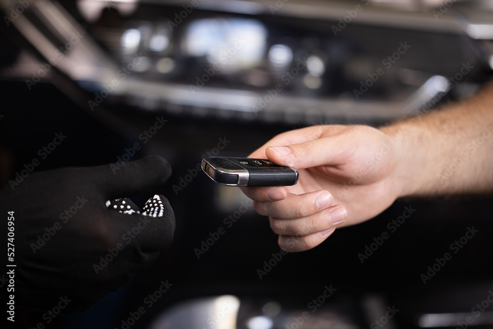 Man owner of the auto gives the keys to the car repairman. Close up shot of hands of male client giving car key to mechanic in auto repair shop. Car repair. Vehicle breaks down