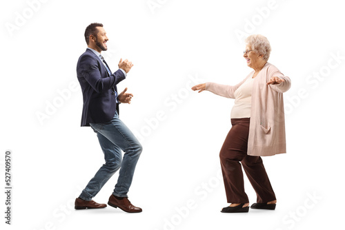 Full length profile shot of a young man dancing with a senior lady