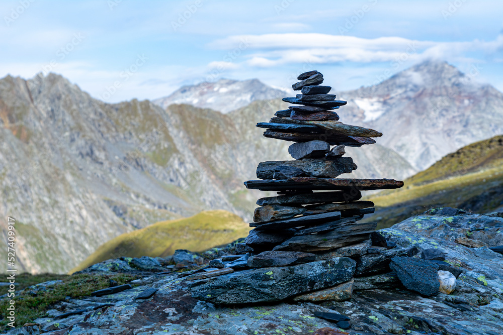 A cairn (also called stone man or stone mandl) in the Austrian Alps used as a trekking path sign.