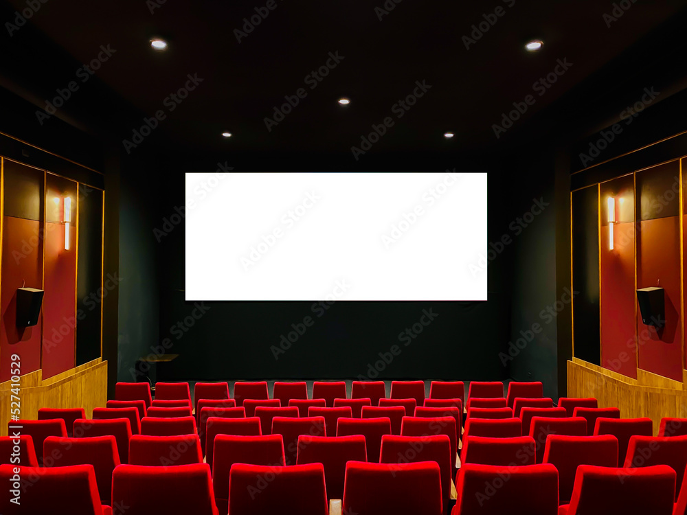 Fototapeta premium Interior of art cinema movie house red soft seating in a row. Large flat white screen mock-up on the wall for advertising.