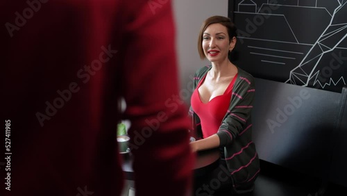 Portrait of excited smiling woman waving looking away greeting man entering cafe. Loving beautiful Caucasian adult girlfriend meeting with boyfriend dating indoors. Relationship and happiness concept