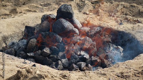 Hot coals and rocks smoldering as the imu is prepared for a luau in Hawaii. photo