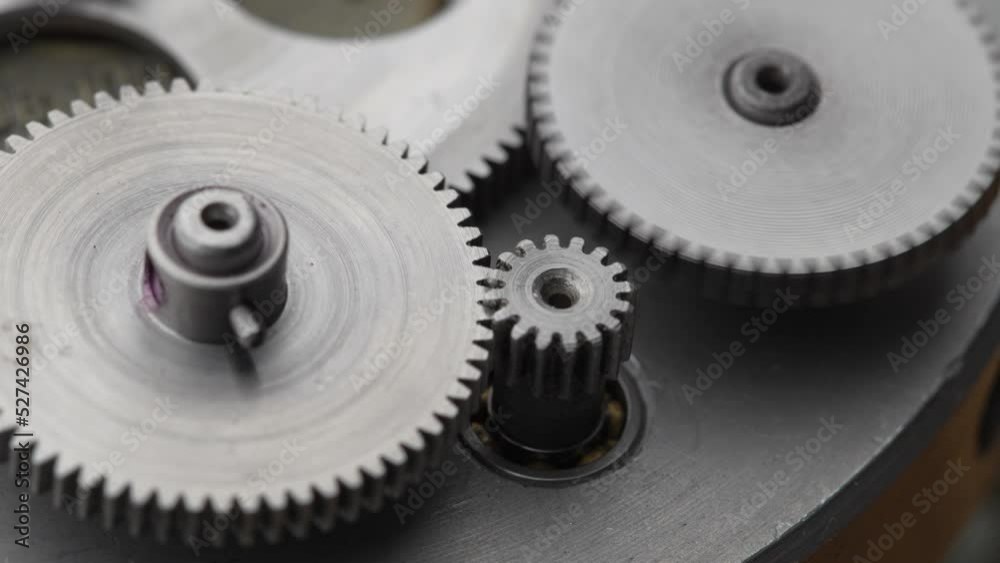 Gears rotating in a mechanical device. Machine metal gears rotating abstract. Cog wheels machinery, close up, macro Gears rotating in a mechanical device. Machine metal gears rotating abstract. Cog wheels machinery, close up, macro