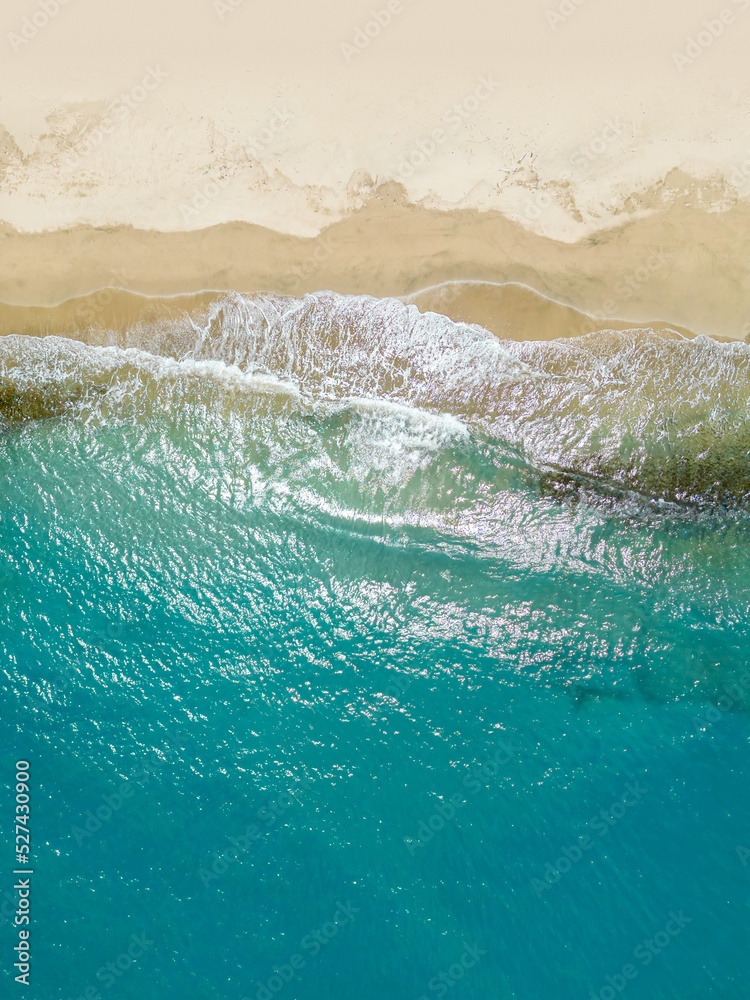An aerial view of a tropical sandy beach and blue ocean.