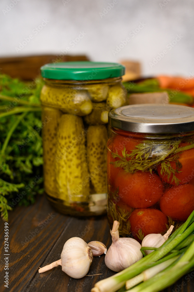 Glass jars with pickled cucumbers and tomatoes Glass jars with pickled cucumbers and tomatoes