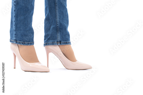 Slender female legs in patent leather shoes with high heels. Dark blue jeans. Fashion and Style. Side view