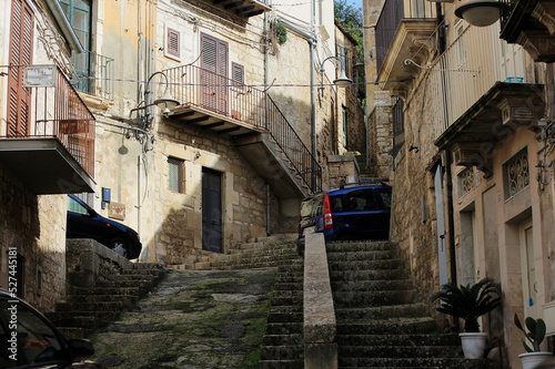 Fototapeta Naklejka Na Ścianę i Meble -  Typical narrow streets of the Sicilian town, Modica, tourism of Italy, historic Italian architecture, European urban planning.