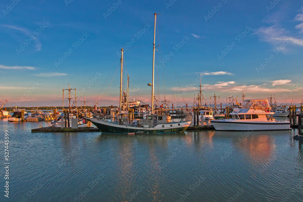 Fishing Boats in Marina and a blue cloudy sky. This marina is located in the Steveston area of Richmond. The fishing village formed in this place was the first settlement on the territory of  Richmond