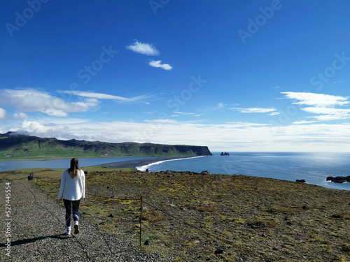 Couple vacation girlfriend walking along the shore in iceland black beach in iceland with the sea