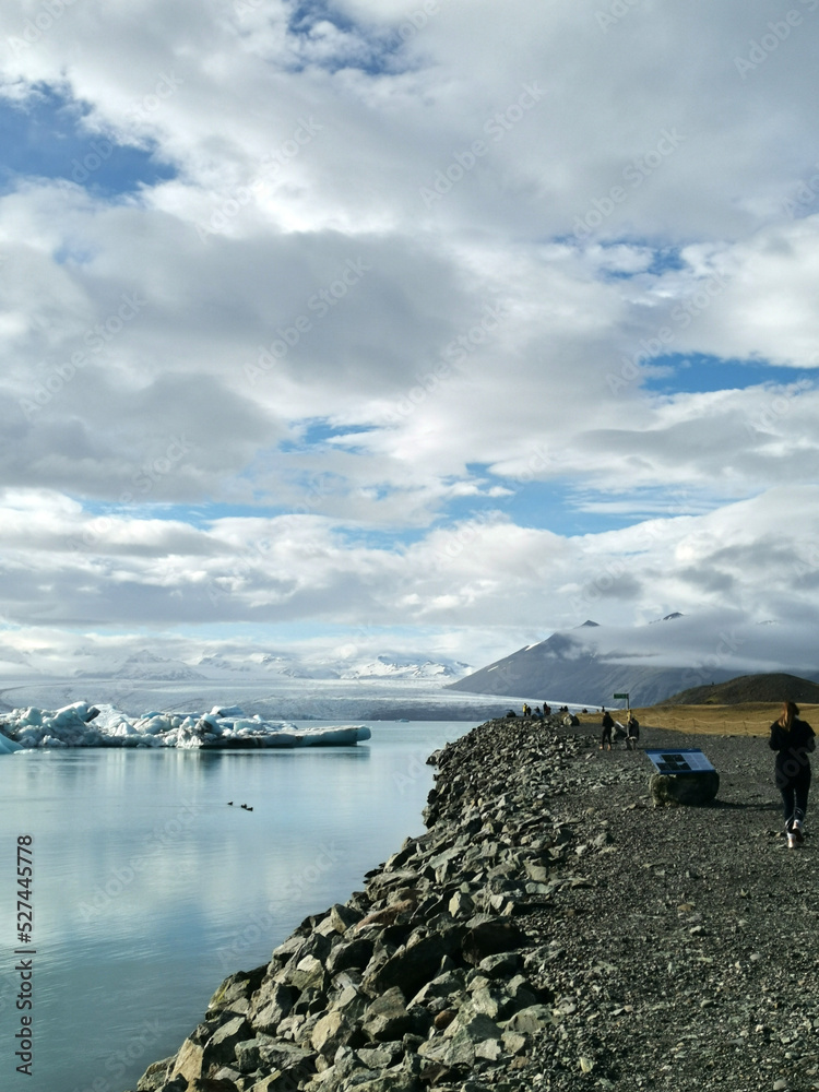 Fototapeta premium A tourist touristiv viewpoint stop at the Jökulsárlón glacier iceberg bridge next to road strett trip with ice in water at iceland island