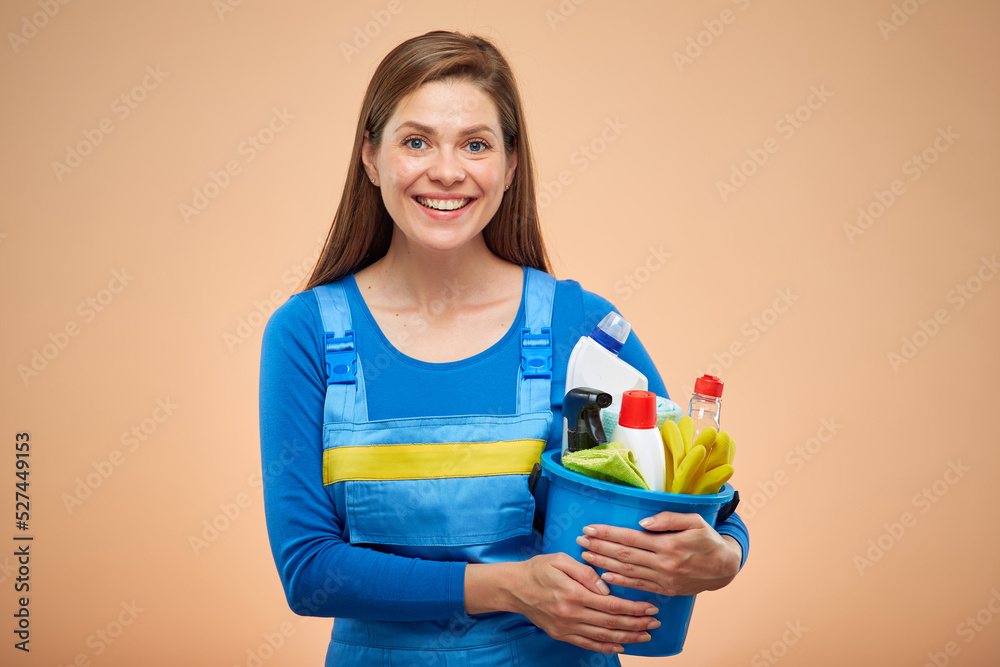 Happy woman in overalls with cleaning products. isolated portrait on brown beige background. Happy woman in overalls with cleaning products. isolated portrait on brown beige background.