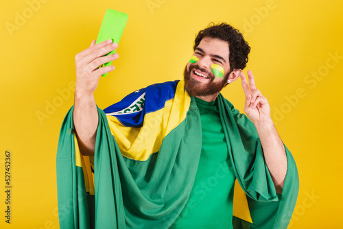 Fotografie, Obraz caucasian man with beard, brazilian, soccer fan from brazil, taking self portrait with cellphone, selfie, smartphone