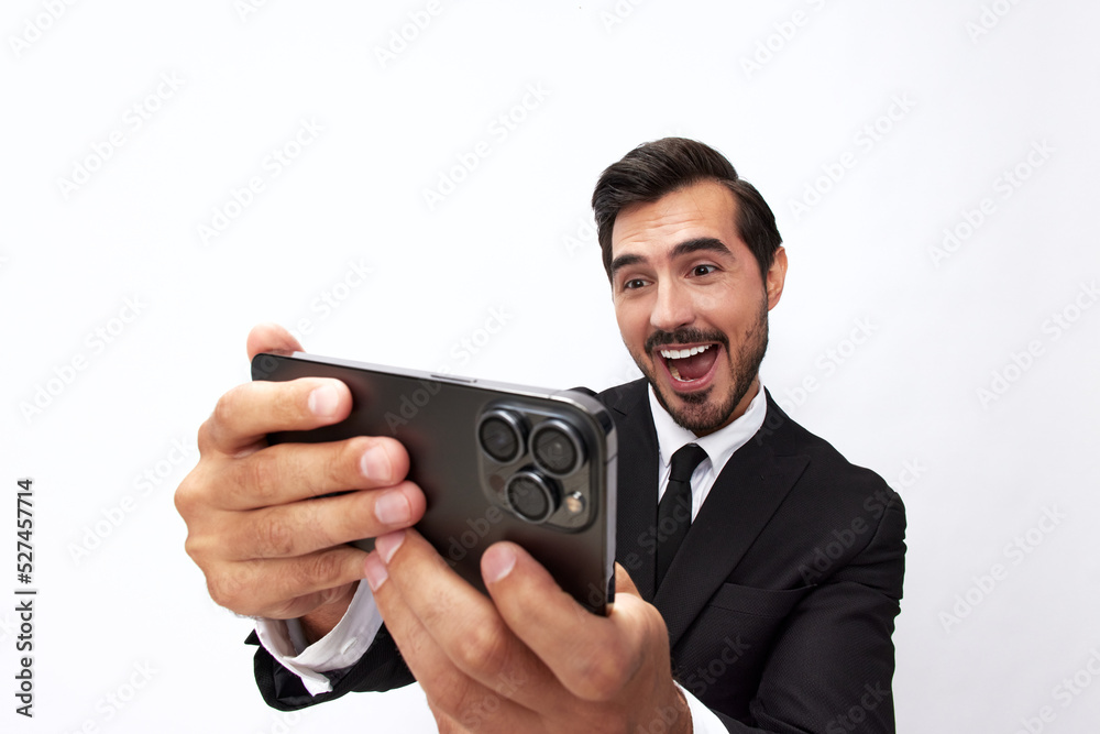 Man businessman holding phone in hand looking into screen video call and selfies and smile with teeth. Close-up wide angle photo gray isolated background Man businessman holding phone in hand looking into screen video call and selfies and smile with teeth. Close-up wide angle photo gray isolated background