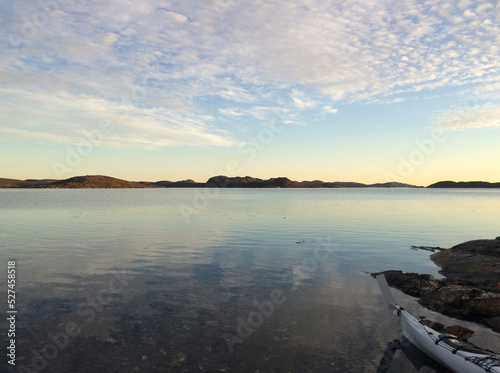 Kayak in the water in Greenland Fjord at sunrise