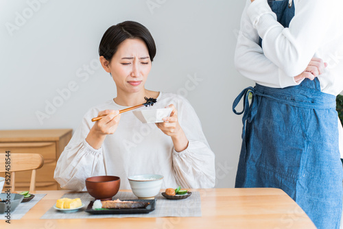 まずそうにごはんを食べる女性 photo