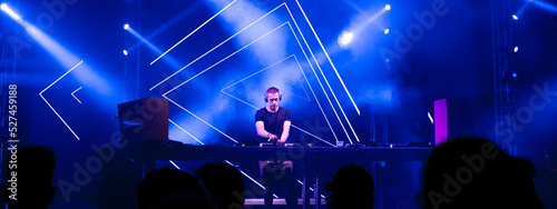 Fotografija Dj playing techno music on the stage at night summer concert