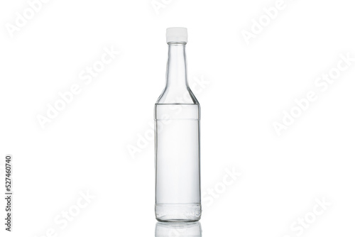 Glass transparent bottle with a white cap on a white background.