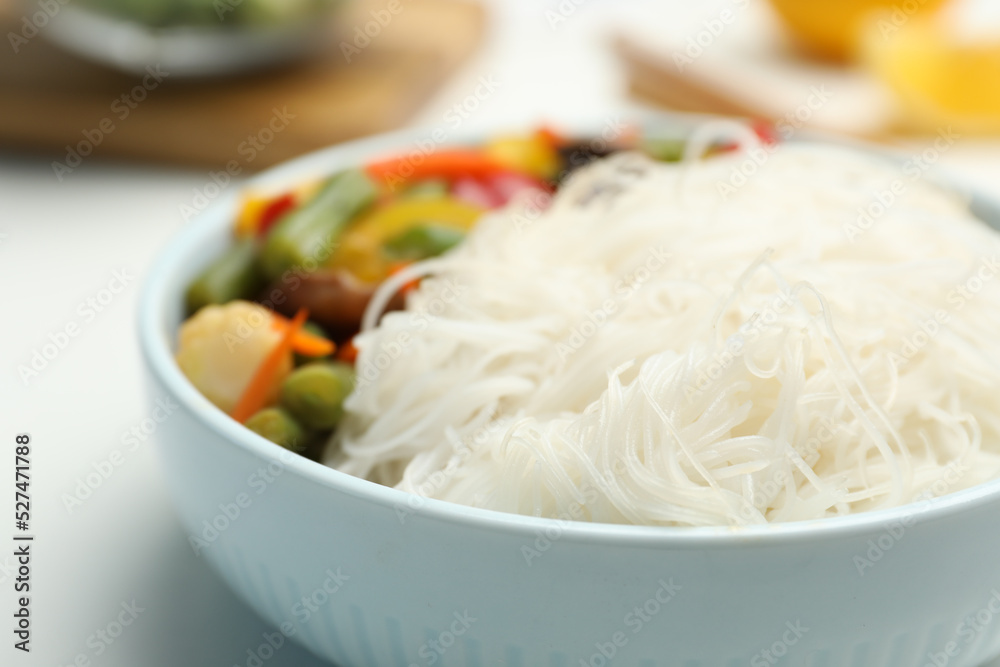 Tasty cooked rice noodles with vegetables on table, closeup Tasty cooked rice noodles with vegetables on table, closeup