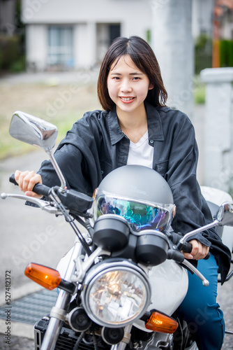 バイクにまたがる女性 a motor bicycle