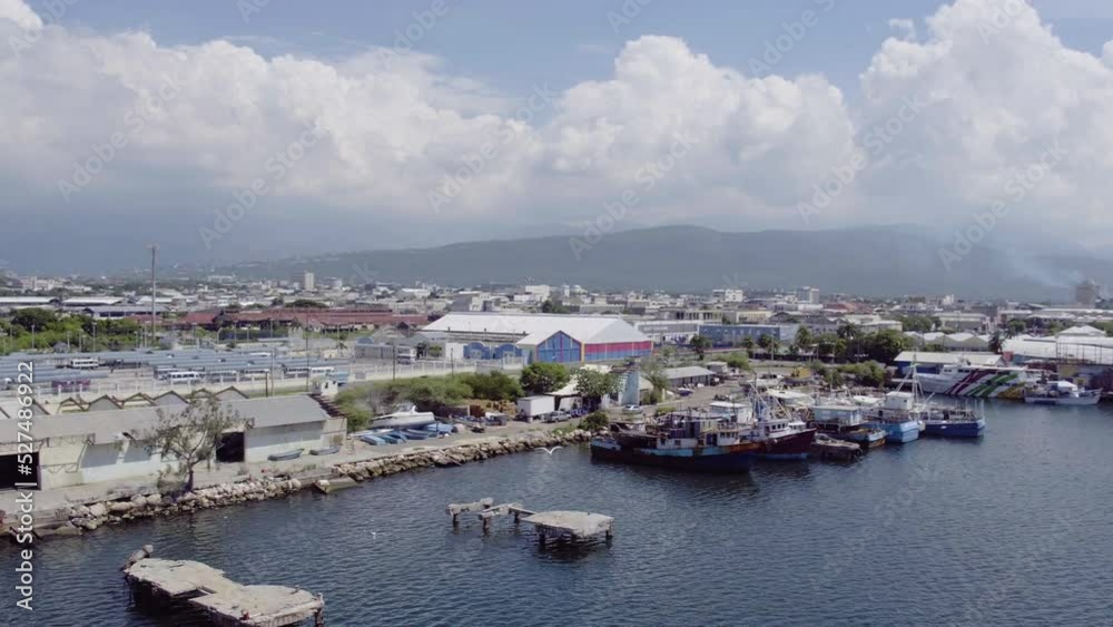 Aerial view of the old dock and waterfront in Kinston Jamaica with the camera turning right with a seagull in flight Aerial view of the old dock and waterfront in Kinston Jamaica with the camera turning right with a seagull in flight