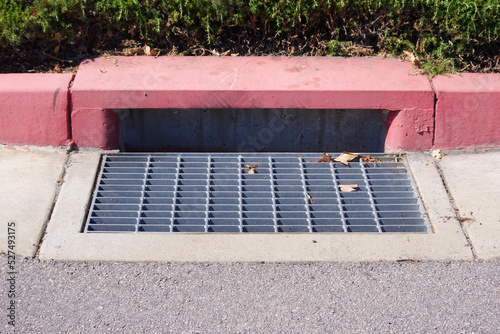 Canvastavla Rain storm water drain gutter on a city street red curbside