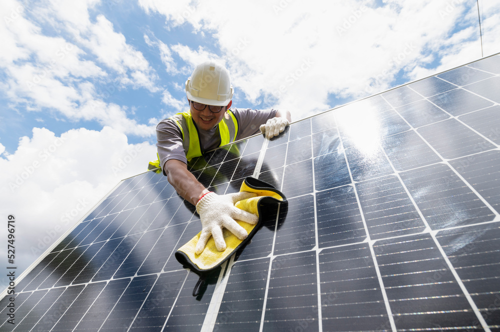Engineer cleaning solar panels Hand wipe the solar panel from dirt.Cleaning mini photovoltaics which installed beside Engineer cleaning solar panels Hand wipe the solar panel from dirt.Cleaning mini photovoltaics which installed beside