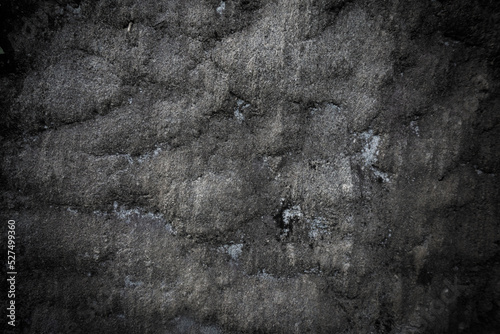 Close-up black worn textured stone surface. Rock texture detail. Abstract grunge background for designers. The rocky backdrop.