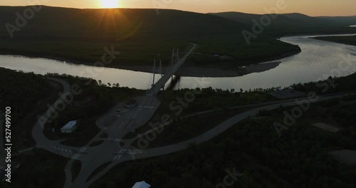 Aerial view over the Utsjoki town, towards the Sami Bridge and Teno river, midnight sun in Utsjoki, Finland - rising, tilt, drone shot photo