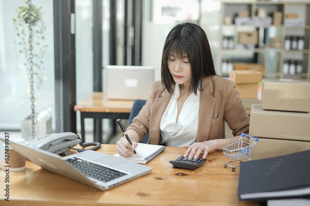 Asian businesswoman using calculator and financial documents at the table office, business financial concept. Asian businesswoman using calculator and financial documents at the table office, business financial concept.