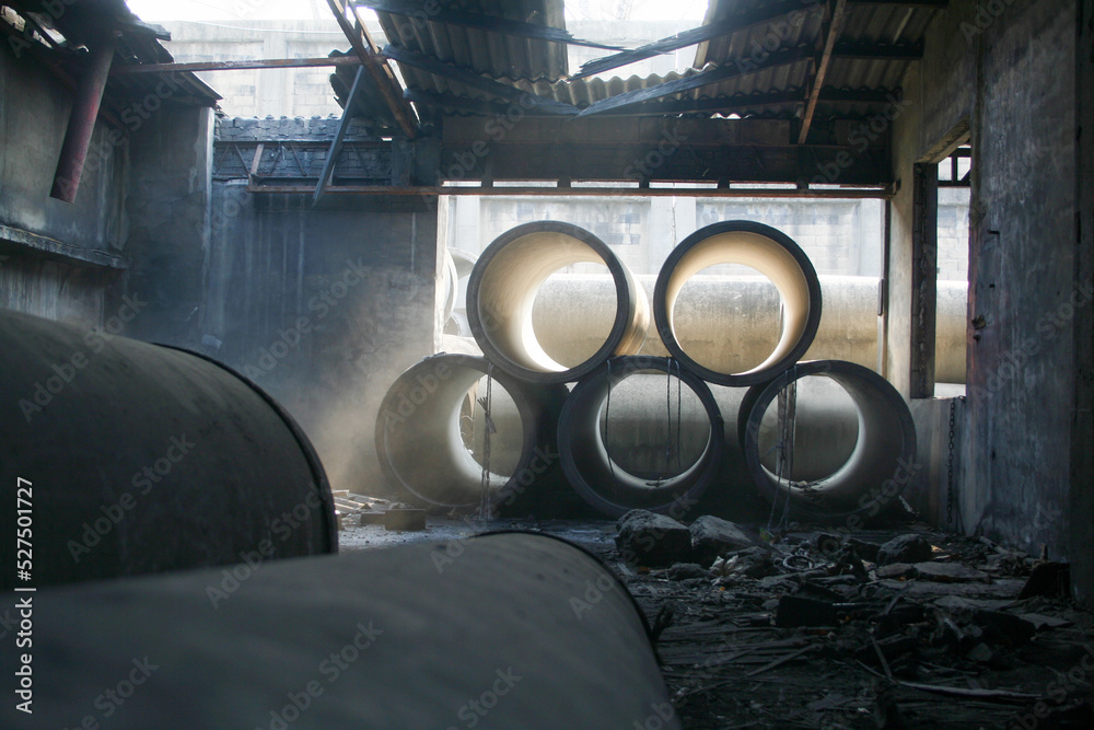 Stack of large concrete cylinders in abandoned warehouse. Stack of large concrete cylinders in abandoned warehouse.