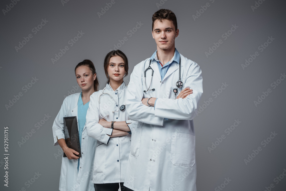 Shot of professional team of three doctors dressed in uniform posing with crossed arms. Shot of professional team of three doctors dressed in uniform posing with crossed arms.
