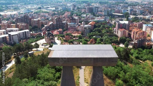 Aerial of Mitrovica with a monument in the foreground and a view of the city photo