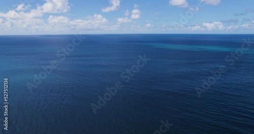 Blue Pacific ocean waters of Hawaii below cloudy sky, drone view. photo