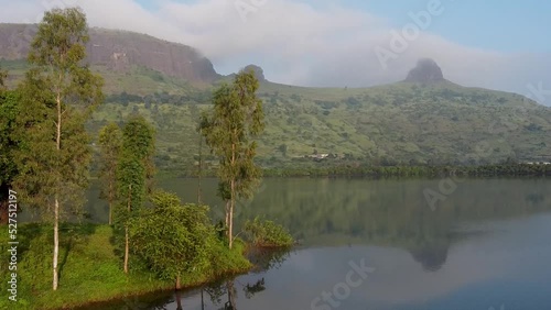Reflections On Calm Lake Near Trimbakeshwar Mountain Range In Western Ghats, Nashik, India. Pullback Shot photo