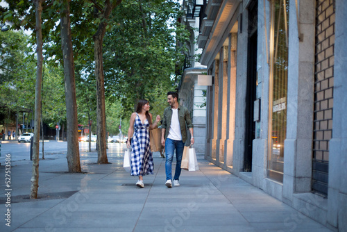 Couple walking down a commercial street with two shopping bags