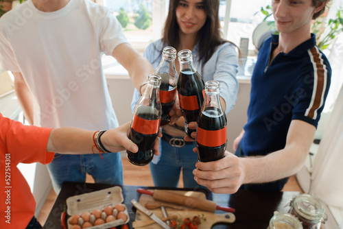 Shot of home party of four friends celebrating event with cola and homemade pizza.