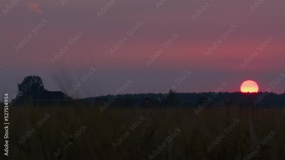 Timelapse of sun setting in countryside. Picturesque sunset over village.