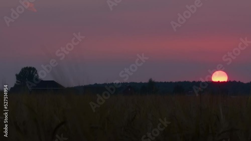 Timelapse of sun setting in countryside. Picturesque sunset over village.