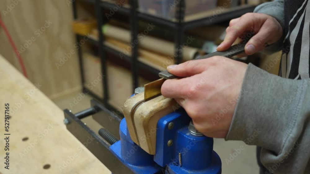 Man's Hands Deburring Edge of Brass Plate Gripped in a Vise to Remove Fine Amounts of Material - close-up dolly