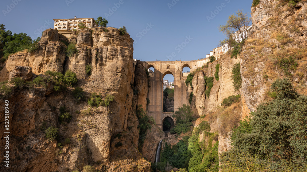 View of Ronda city, Malaga province, Andalusia, Spain. The Puente Nuevo "New Bridge" connects the two sides of the city by crossing the the Guadalevín river canyon also known as El Tajo canyon. - obrazy, fototapety, plakaty 