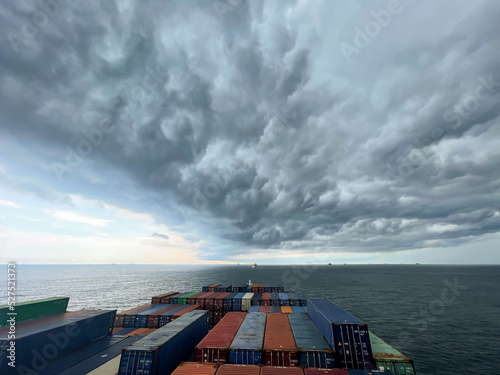 Ultra large container vessel at anchor view on the forward part during stormy weather and grey clouds