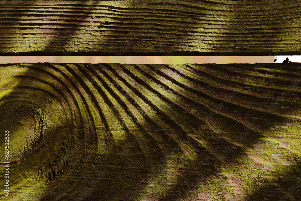 Naklejka premium Close-up of wooden boards with visible grain lines and a narrow gap. The abstract pattern and lighting create the illusion of a sculpted landscape from above