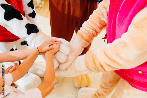 hands. team game of Kids and artists in stage costumes at a children's holiday.