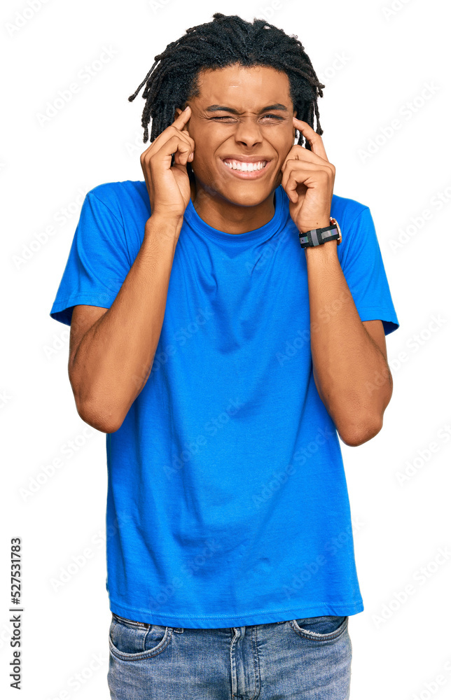 Young african american man wearing casual clothes covering ears with fingers with annoyed expression for the noise of loud music. deaf concept. Young african american man wearing casual clothes covering ears with fingers with annoyed expression for the noise of loud music. deaf concept.